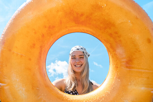 Woman holds an inflatable ring outdoors during summer