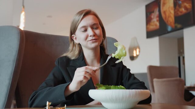 Caucasian woman in bistro sampling crisp salad, influencer energy, white ceramic bowl and gentle dressing drizzle, natural light, slight smile and thoughtful bite, modern interior and relaxed lunch