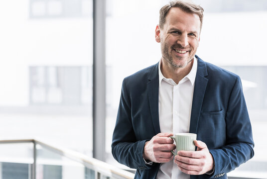 Portrait of smiling businessman having a coffee break