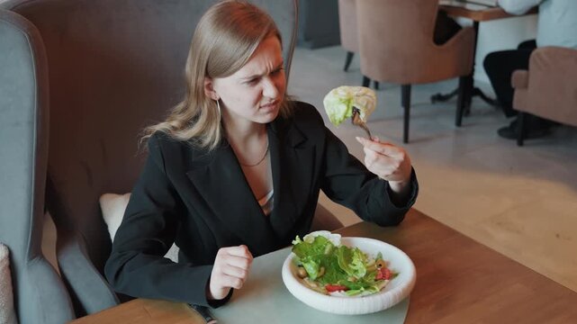 Displeased man rejects salad. Skeptical leader pushes aside vegetable dish in sophisticated setting. Concerned executive displays doubt by turning away from healthy food in upscale dining environment