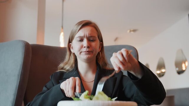 She identifies unusual tang in her lunchtime meal. Female detects atypical sharp taste in her noon salad bowl. Woman experiences surprising and distinct sour flavor while having her midday salad