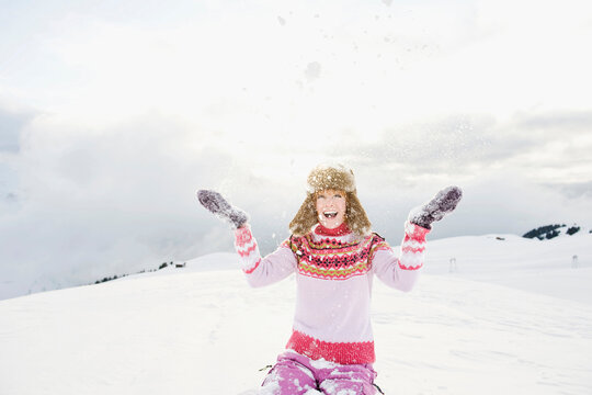 Italy, South Tyrol, Seiseralm, Woman throwing snow, portrait