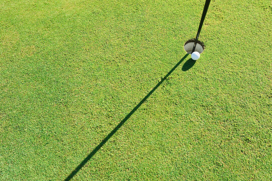 A golf ball lies near the hole on a green in Kastelruth Italy