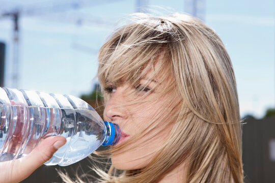 Close-up of a young woman in Cologne, Germany, quenching her thirst with a refreshing drink of water