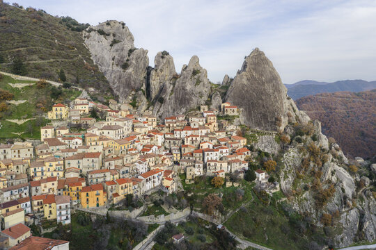 Aerial view of the historic village of Castelmezzano nestled among the dramatic jagged rock formations of the Dolomiti Lucane mountains in Castelmezzano, Basilicata, Italy.