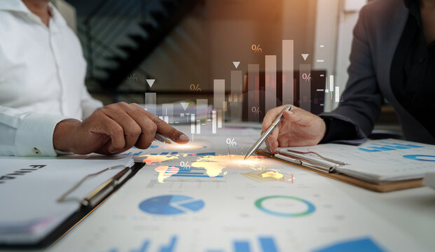 Corporate team analyzing global market data and financial charts on office desk
