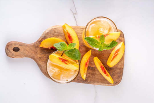 Summer cold drink, peach iced tea slushie cocktail. Shaved ice non-alcohol cold beverage, peach juice infused tea, copy space