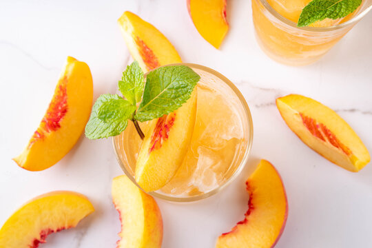 Summer cold drink, peach iced tea slushie cocktail. Shaved ice non-alcohol cold beverage, peach juice infused tea, copy space