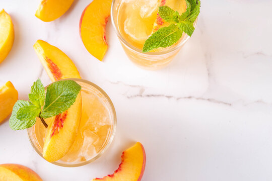 Summer cold drink, peach iced tea slushie cocktail. Shaved ice non-alcohol cold beverage, peach juice infused tea, copy space