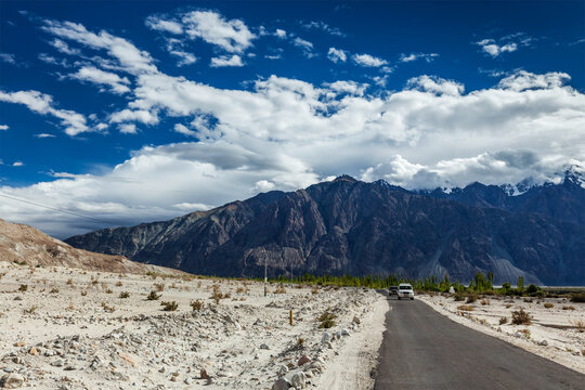 An asphalt road in Himalayas with cars. Nubra valley, Ladakh, India
