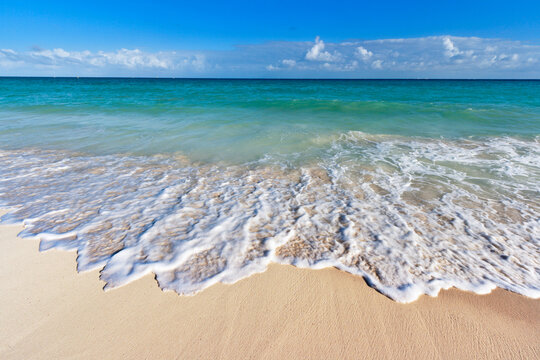 Scene featuring beautiful beach and waves of Caribbean Sea