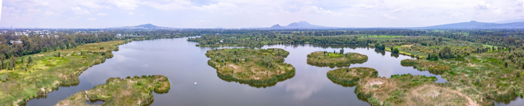 Aerial view of Xochimilco canals and chinampas surrounded by lush vegetation and wetlands in Xochimilco, Mexico City, Mexico.