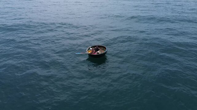 Aerial view of a vietnamese fisherman in a traditional basket boat fishing in the open sea
