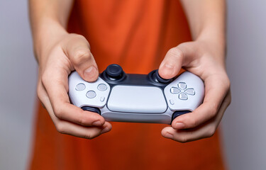 Gamer hand using video game console controller. Playing games concept. Man play a football game with video game controller. Child holding a game controller © Yevhen