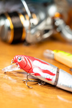 Red jointed fishing lure on a wooden table The Concept of sport fishing