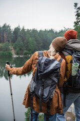 Fototapeta premium Couple enjoys a peaceful hike in a vibrant autumn forest by a tranquil lake