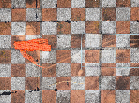 Aerial view of a checkerboard terrace featuring geometric patterns and an orange safety mesh in Belgrade, Serbia.