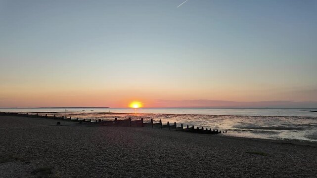 Golden hour sunset at Whitstable Beach, Kent, Southeast England, United Kingdom. Slow motion walking POV.