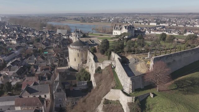 A close aerial view of the round tower and stone walls of Chateau d'Amboise above the rooftops of the town.