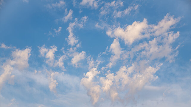 Soft Blue Sky with Fluffy White Clouds and Airy Atmosphere 