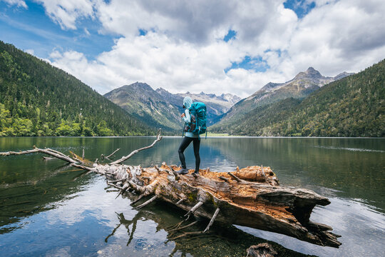 Hiking woman on a one plank bridge in high altitude mountains