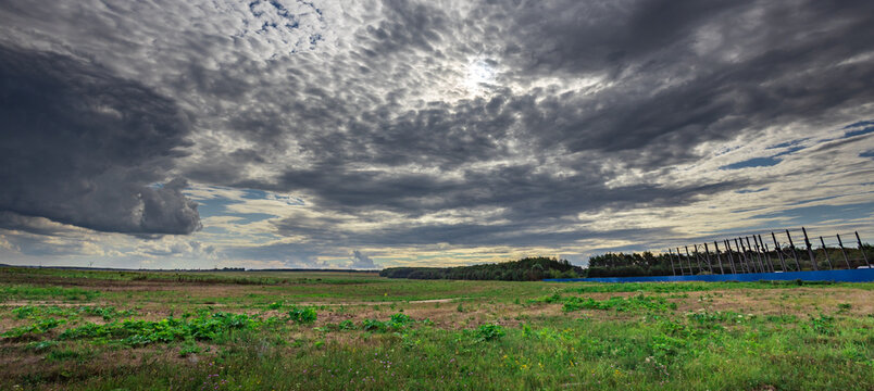 Dramatic clouds loom over open grassland