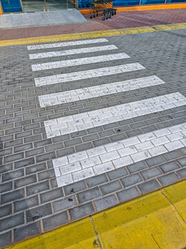 Pedestrian crosswalk on paved street with yellow curb, urban safety theme