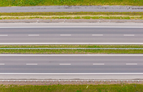 Aerial view of the Droga Ekspresowa S6 highway featuring a modern dual carriageway with green grass medians and shoulders in Slupsk, Pomeranian Voivodeship, Poland.