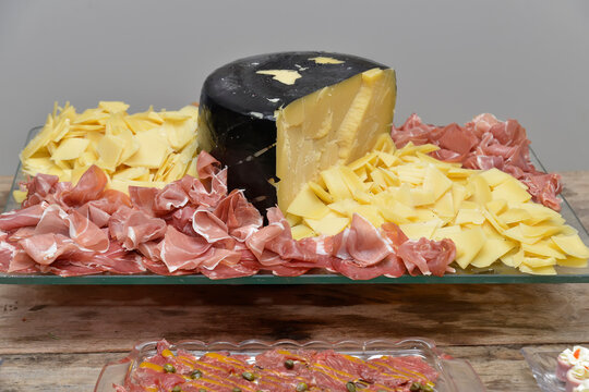 Gourmet charcuterie board featuring artisanal black rind cheese and cured ham