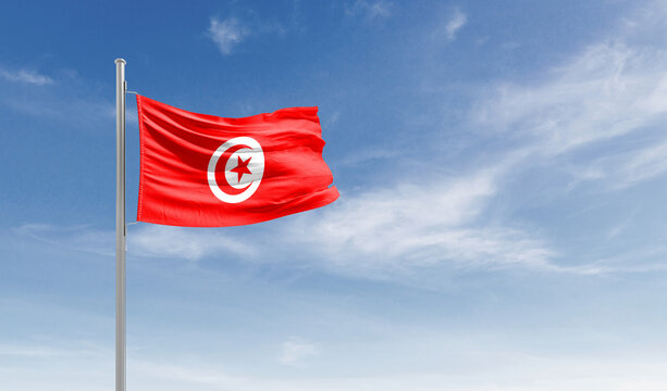 Tunisia national flag waving in the sky.