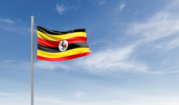 Uganda national flag waving in the sky.