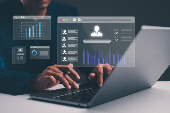 A person uses a laptop with transparent digital interfaces showing charts, profiles, and data analytics overlays.