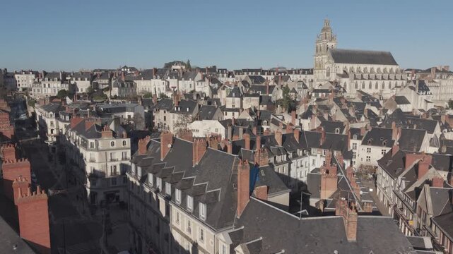 An aerial view looks closely over the rooftops of Blois toward its tall cathedral tower in the Loire Valley.