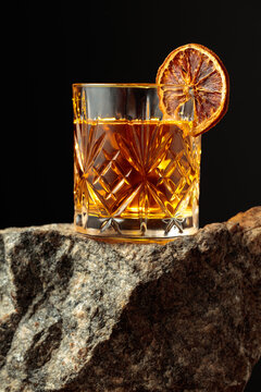 Old-fashioned cocktail with dried orange slice.