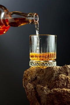 Whiskey is poured from a bottle into a glass.