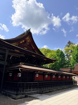 Main shrine building of Kitano Tenmangu Shrine under a blue sky in Kyoto, Japan