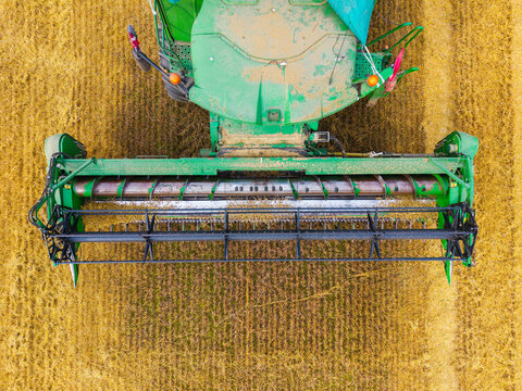 Aerial view of a broken combine harvester in a golden wheat field during harvest season in Kazupe, Dobele Municipality, Latvia.