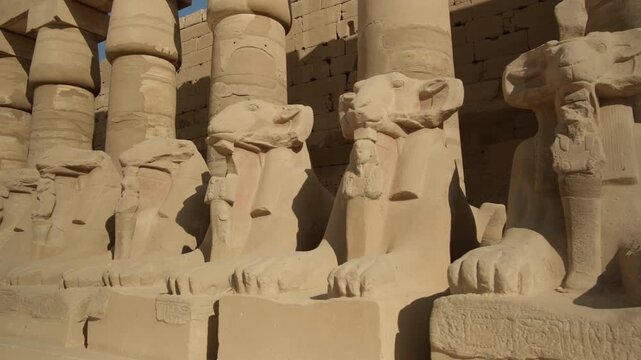 Ancient statues of ram-headed sphinxes along Bubastian columns in courtyard of Karnak Temple Complex, Luxor, Egypt