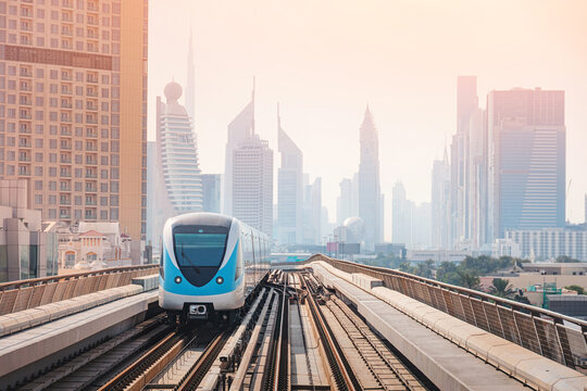 Metro electric train moving on elevated railway track in a modern city with skyscrapers