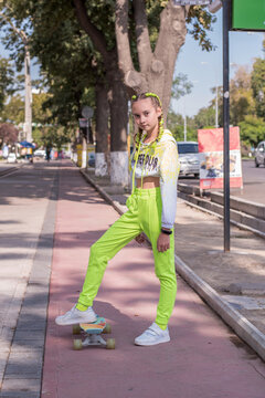Skater girl standing on colorful city sidewalk. Concept: Active urban youth lifestyle, Autumn school season fashion retail banner. 