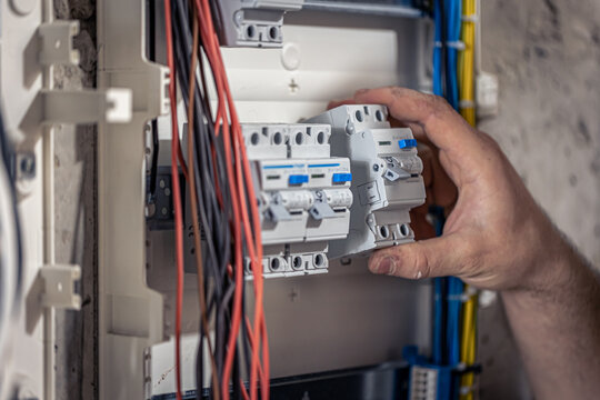 Professional Electrician Installing Circuit Breakers in Electrical Distribution Panel for Safe and Reliable Power Systems