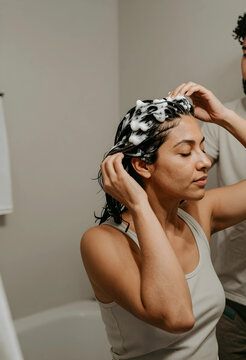 Woman washing Her hair with shampoo and foam in a bathroom, self care and hygiene routine