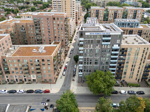 Aerial view of a modern residential housing development with brick apartment buildings and a street with parked cars in London, England, United Kingdom.