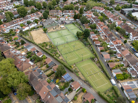 Aerial view of Gunnersbury Triangle Sports Field with tennis courts surrounded by residential houses and greenery in a suburban neighborhood London, England, United Kingdom.