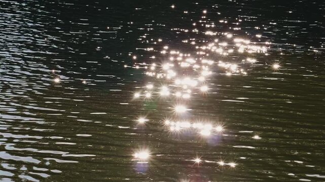 Sun Glare and Sparkles Reflecting on Rippled Water Surface