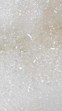 Thousands of tiny bubbles shimmer and pop in a thick, white soapy foam, creating a gentle, mesmerizing movement perfect for concepts of hygiene, relaxation, and cleanliness