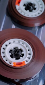 Spinning Audio Cassette Reels. Macro view of magnetic tape reels rotating inside a transparent cassette mechanism.