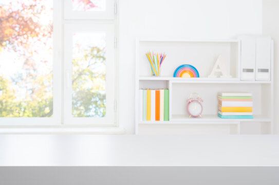 White table top for educational purposes on blurred bookshelf and autumn window interior background