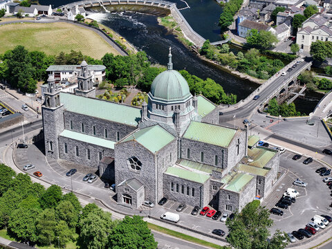 Aerial view of Galway Cathedral with its distinctive green dome and stone architecture, situated near the river Corrib and Salmon Weir Bridge in Galway, County Galway, Ireland.