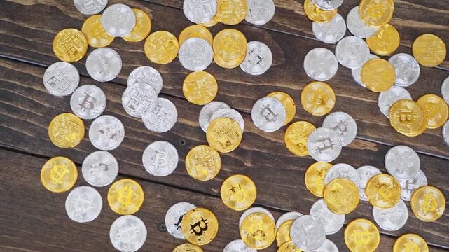Coins made of gold and silver mixed with paper currency are spread across a rustic wooden surface to illustrate the complex world of modern digital finance and tangible asset management for.